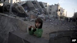 Enfant palestinien près des décombres de la chaîne de télévision Al-Aqsa du Hamas, visée lundi par des frappes aériennes.