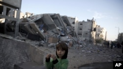 Un niño palestino está de pie, junto a los escombros del edificio de la estación de televisión Al-Aqsa de Hamas.