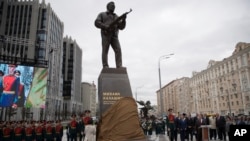 A new monument to Russian firearm designer Mikhail Kalashnikov is unveiled during an official ceremony in Moscow, Russia, Tuesday, Sept. 19, 2017.
