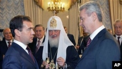 Russian President Dmitry Medvedev, (L) new Moscow Mayor Sergei Sobyanin (R) and Russian Orthodox Patriarch Kirill (C) toast after an inauguration ceremony in Moscow, 21 Oct 2010