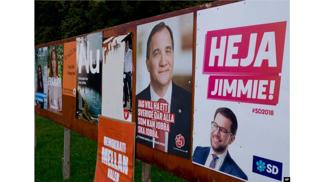This photo shows an election poster or Jimmie Akesson, right, leader of the far-right Sweden Democrats, and Social Democratic Prime Minister Stefan Lofven, second from right. in Flen, Sweden, Aug. 30, 2018. Sweden's 7.3 million voters go to polls on Sept. 9 to elect a new parliament and government.