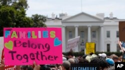 FILE - In this June 20, 2018, file photo, activists march past the White House to protest the Trump administration's approach to illegal border crossings and separation of children from immigrant parents in Washington.