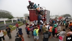 Central American migrants pack into the back of a trailer truck as they begin their morning trek as part of a thousands-strong caravan hoping to reach the U.S. border, in Isla, Veracruz state, Mexico, Nov. 4, 2018.