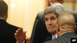 U.S. Secretary of State John Kerry, set to participate in talks on Syria, waves as he arrives at a hotel in Vienna, Nov. 13, 2015.