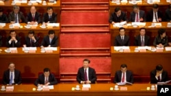 Chinese President Xi Jinping, center, listens to a speech during the opening session of the Chinese People's Political Consultative Conference in Beijing's Great Hall of the People, March 3, 2017. 