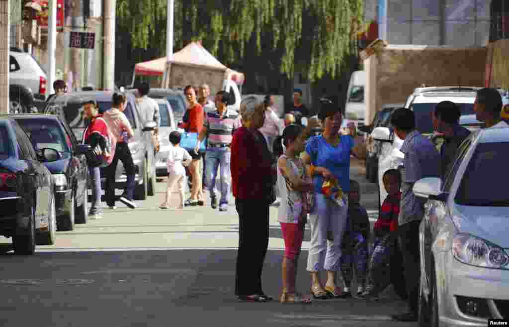 People stand outside their homes after a large earthquake hit Dingxi, Gansu province, July 22, 2013.