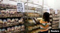 FILE - A worker arranges bread for sale inside a supermarket in Harare, March 26, 2009. 