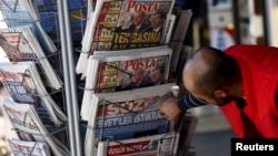 FILE - A man looks at newspapers at a kiosk in Diyarbakir, Turkey, following Sunday's elections, Nov. 2, 2015.