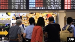 17일 태풍 낭카가 일본 서부 지역을 강타한 가운데, 열차 운행이 지연된 오사카 기차역에서 승객들이 전광판 안내문을 읽고 있다.