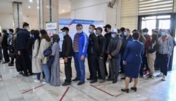 Voters stand in a line at a polling station during a presidential election in Tashkent, Uzbekistan, October 24, 2021.