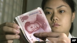 A woman counts counts 100 Yuan notes (file photo)