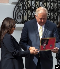 U.S. diplomat Thomas Shannon receives a souvenir from Venezuelan Foreign Minister Delcy Rodriguez after a private meeting with President Nicolas Maduro at Miraflores Presidential Palace in Caracas, Venezuela, June 22, 2016.
