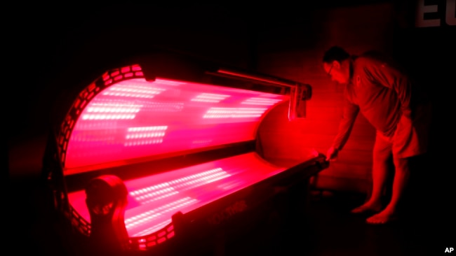In this April 12, 2019, photo, Washington Redskins director of player recovery and assistant athletic trainer Hutch Call demonstrates a full body light pod at the team's NFL football training facility in Ashburn, Va. (AP Photo/Patrick Semansky)