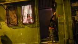 A transgender looks out of a window and a woman reacts as women's rights activists march through Taksim Square to protest against gender violence in Istanbul, on November 25, 2018, on the International Day for the Elimination of Violence against Women.