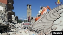 Rescuers work at a collapsed house following an earthquake in Amatrice, central Italy, Aug. 26, 2016.