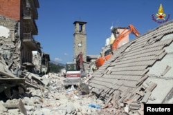 Rescuers work at a collapsed house following an earthquake in Amatrice, Aug. 26, 2016.