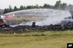 Firefighters spray water on the debris of the plane that crashed on a hotel after an Air France Concorde en route to New York City crashed in Gonesse, outside Paris, shortly after take off, July 25, 2000, slamming into a hotel.