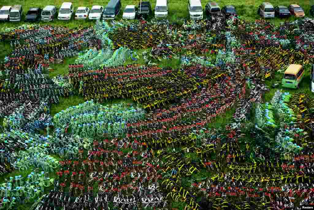 Berbagai jenis sepeda milik perusahaan persewaan sepeda diparkir di sebuah desa di Hangzhou, Zhejiang, China.