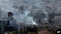 21일 터키 접경 마을 수루크에서 바라본 시리아 코바니 지역에서 쿠르드족과 ISIL의 전투가 계속되는 가운데 연기가 피어오르고 있다.