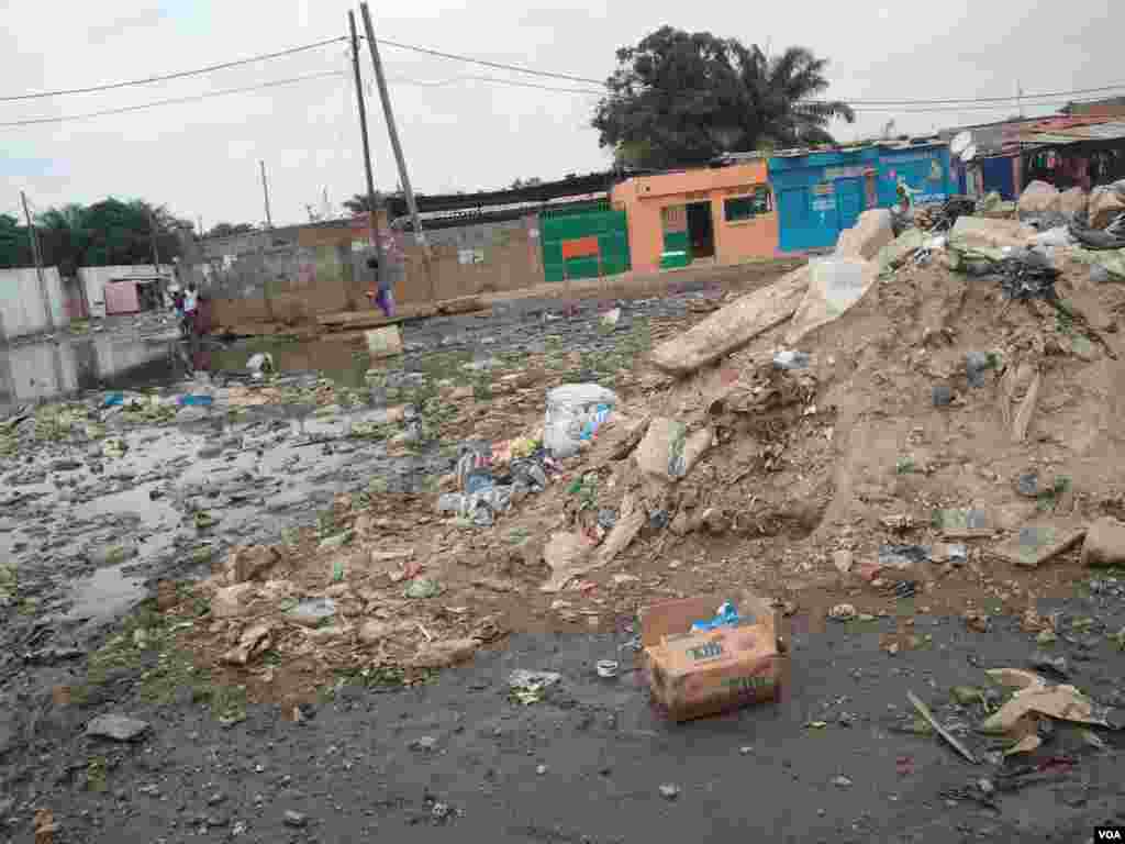 Angola, Luanda. Moradores tentam chegar ao seu destino, evitando a lama e o lixo, consequência das chuvas que se fazem sentir há mais de uma semana. 25 de Abril 2014