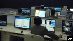 FILE - Scientists and technicians work on their computers to control a rocket launch at the General Satellite Control and Command Center Dec. 12, 2012, in Pyongyang, North Korea.