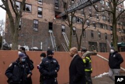 New York Mayor Eric Adam and New York police are seen outside a fire-hit apartment in the Bronx, Sunday, January 9, 2022.