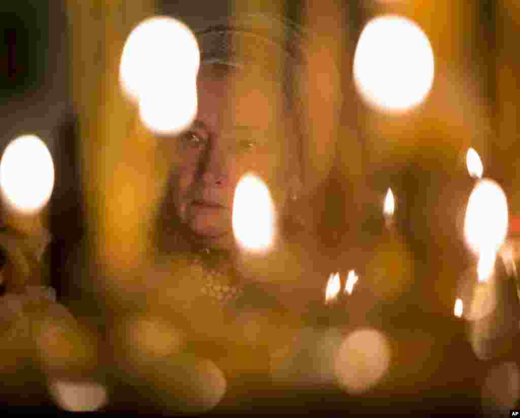 A woman takes part in a memorial religious service for plane crash victims at the St.Isaac&#39;s Cathedral in St.Petersburg, Russia. As a choir sang, the bell of the world&#39;s fourth-largest cathedral was tolling once for each of the 224 victims. Most of the victims were from St. Petersburg or other areas of northwest Russia.