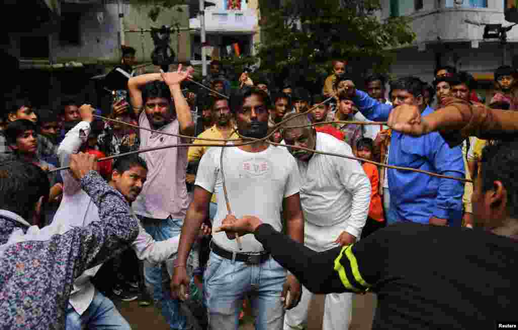 Beberapa pria Hindu melakukan atraksi (stunt) untuk menyambut festival tahunan &quot;Rath Yatra&quot; (prosesi kereta) di Ahmedabad, India.