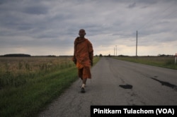 Buddhist monk Sutham Nateetong walks along the road outside Arcola, IN. June 8, 2019.