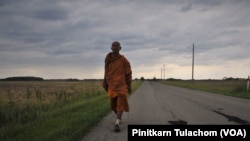 Buddhist monk Sutham Nateetong walks along the road outside Arcola, IN. June 8, 2019.