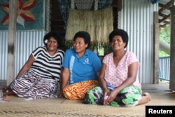 Villager Biusalia Tevita (C) poses for photo in her home for the Thomson Reuters Foundation with village nurse Seruwaia Kula (L), and a neighbor at Wailotua Village No. 1, an inland community of about 200 people that is prone to flooding, cyclones and landslides, about 65 km (40 miles) north of Suva, Fiji, Dec. 8, 2017.