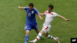 Le joueur Bosniac Anel Hadzic et l'Iranien Ehsan Haji Safi, lors de la coupe du monde2014 au Bresil.