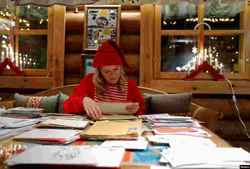 Elina, dressed as a Christmas elf, reads letters from around the world at the Santa Claus&#39; Post Office.