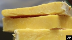 This May 28, 2015 file photo shows cheddar cheese Madison, Wis. The practice of adding color to cheddar cheese reaches back to when cheesemakers in England skimmed the butterfat from milk to make butter.