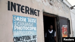 FILE - A Congolese internet cafe owner stands at the entrance of his empty business, in Kinshasa, Democratic Republic of Congo, Jan. 7, 2019.