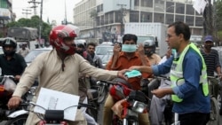 لاہور میں وزارتِ ماحولیات کے اہلکار اسموگ سے بچنے کے لیے لوگوں میں ماسک تقسیم کر رہے ہیں۔