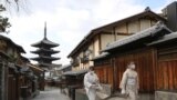 日本京都两名戴着口罩的妇女走过空荡荡的街头。（路透社2021年1月13日）