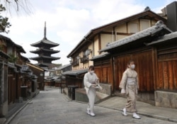 易富賢認為，中國2035年的年齡結構將類似日本2018年。圖為日本京都兩名戴著口罩的婦女走過空蕩蕩的街頭。 （2021年月13日資料照）