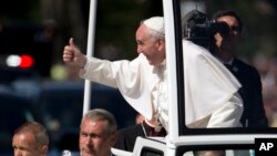 Paus Fransiskus mengacungkan jempol ke arah kerumunan warga dari kendaraan "Popemobile" dalam parade di Washington DC.