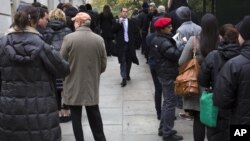 A voter walks between people waiting for their chance to cast their ballots at New York City Hall, November 6, 2012.