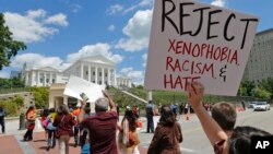 Manifestantes protestan ante la Corte de Apelaciones del 4o. Circuito en Richmond, Virginia, pidiendo el rechazo del racismo y la xenofobia.