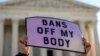 A pro-choice demonstrator holds a sign outside the United States Supreme Court as the court hears arguments over a challenge to a Texas law that bans abortion after six weeks in Washington, November 1, 2021. 