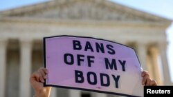 A pro-choice demonstrator holds a sign outside the United States Supreme Court as the court hears arguments over a challenge to a Texas law that bans abortion after six weeks in Washington, Nov. 1, 2021. 