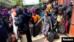 FILE - Rohingya refugees collect aid supplies including food and medicine, sent from Malaysia, at Kutupalang Unregistered Refugee Camp in Cox’s Bazar, Bangladesh, Feb. 15, 2017.