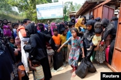 FILE - Rohingya refugees collect aid supplies including food and medicine, sent from Malaysia, at Kutupalang Unregistered Refugee Camp in Cox’s Bazar, Bangladesh, Feb. 15, 2017.