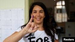 Seorang perempuan menunjukkan jarinya yang ditandai tinta setelah memberikan suaranya pada pemilu parlemen di Beirut, Lebanon, 6 Mei 2018. 