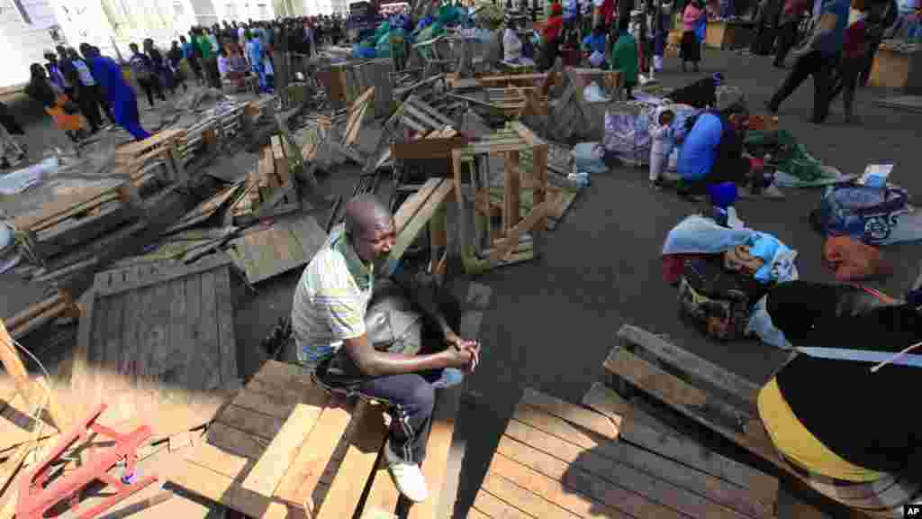 A Zimbabwean vendor ponders his next move after he had his wares removed by police from the streets of Harare, Wednesday, July, 8, 2015. Minor scuffles ensued as police officers drove out thousands of vendors selling their wares on the sidewalks and pavements of Harare.