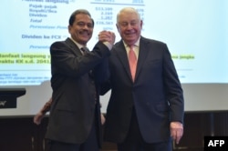 Richard C. Adkerson (R) Director President and Chief Executive Officer (CEO) of Freeport-McMoran Inc and former CEO of PT. Freeport Indonesia Chappy Hakim (L) pose for photographers after a press conference in Jakarta on February 20, 2017. US mining giant Freeport-McMoRan announced on February 18, the head of its Indonesian unit had resigned amid a row with the government that has halted production at a major copper mine.