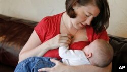 FILE - Jessica Ewald breast-feeds her 5-month-old son, Bennett, at her home in Oakbrook Terrace, Ill., Sept. 14, 2011.