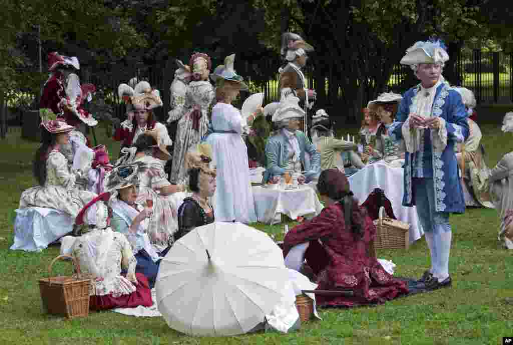 People dressed in costumes relax besides the Friedenstein Castle at the Baroque Festival in Gotha, Germany, Aug. 26, 2017.